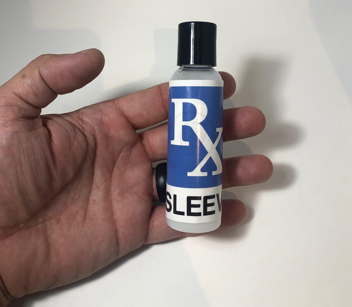 Hand holding penis sleeve lube